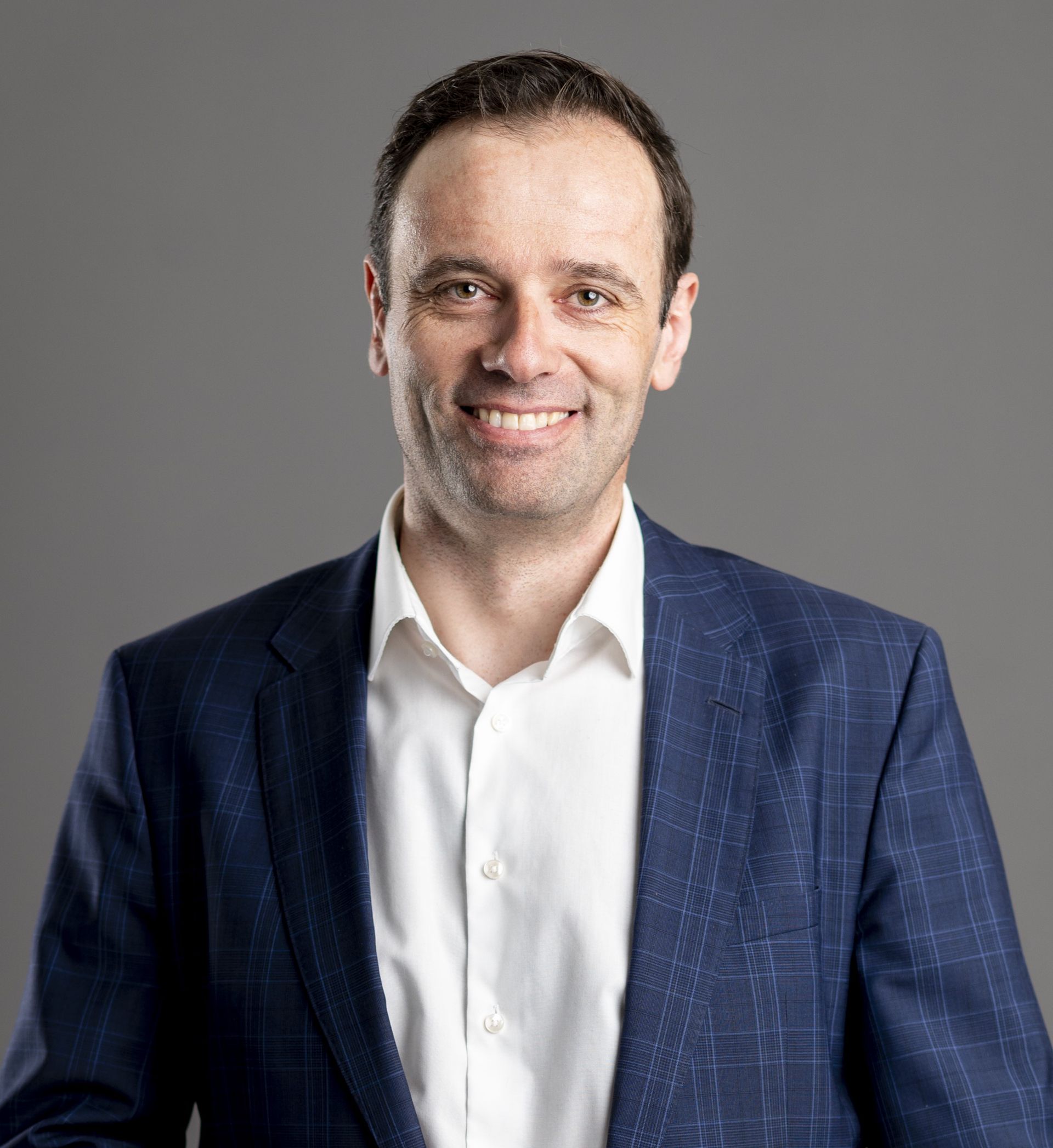 Mann im Anzug lächelt, Porträtaufnahme.